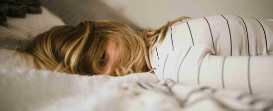 Blonde woman in a white sweater sleeping