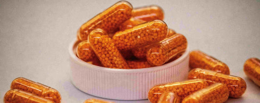 orange-colored pills spread around a white surface