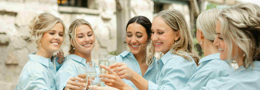 6 women shown cheering with drinks