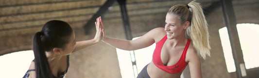 Two women in gym clothes smiling after taking the best supplements for a faster metabolism