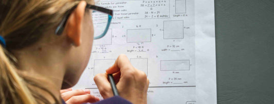 female working math on a paper after taking one of the best supplements for enhancing brain health