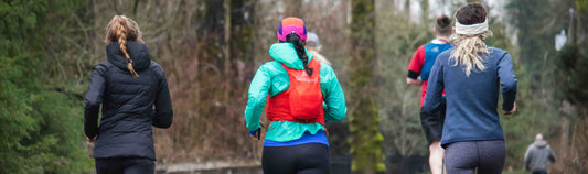 Three women running in a forest