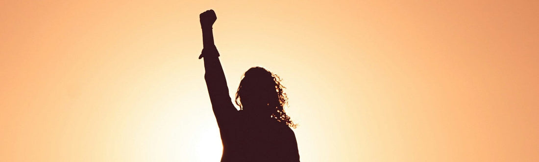 woman with her hands up on a sunrise asking "What Is the Best Supplement for Low Energy?"