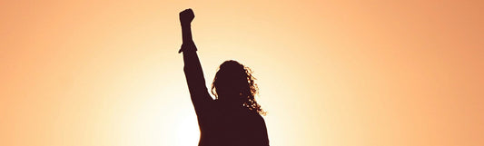 woman with her hands up on a sunrise asking "What Is the Best Supplement for Low Energy?"