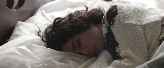 Woman sleeping on a bed after taking natural remedies for deep sleep