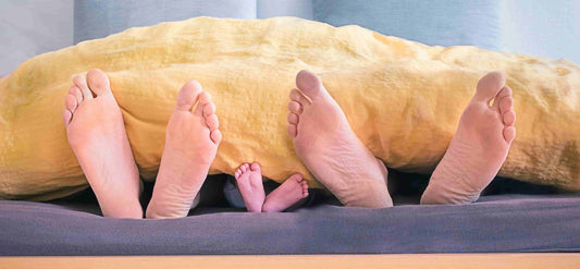A family of three sleeping on a bed after taking one of the top ten sleeping pills