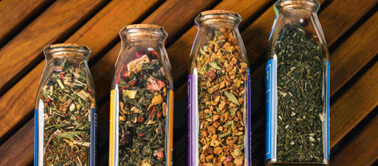 4 clear glass vials holding supplements, herbs, and minerals.